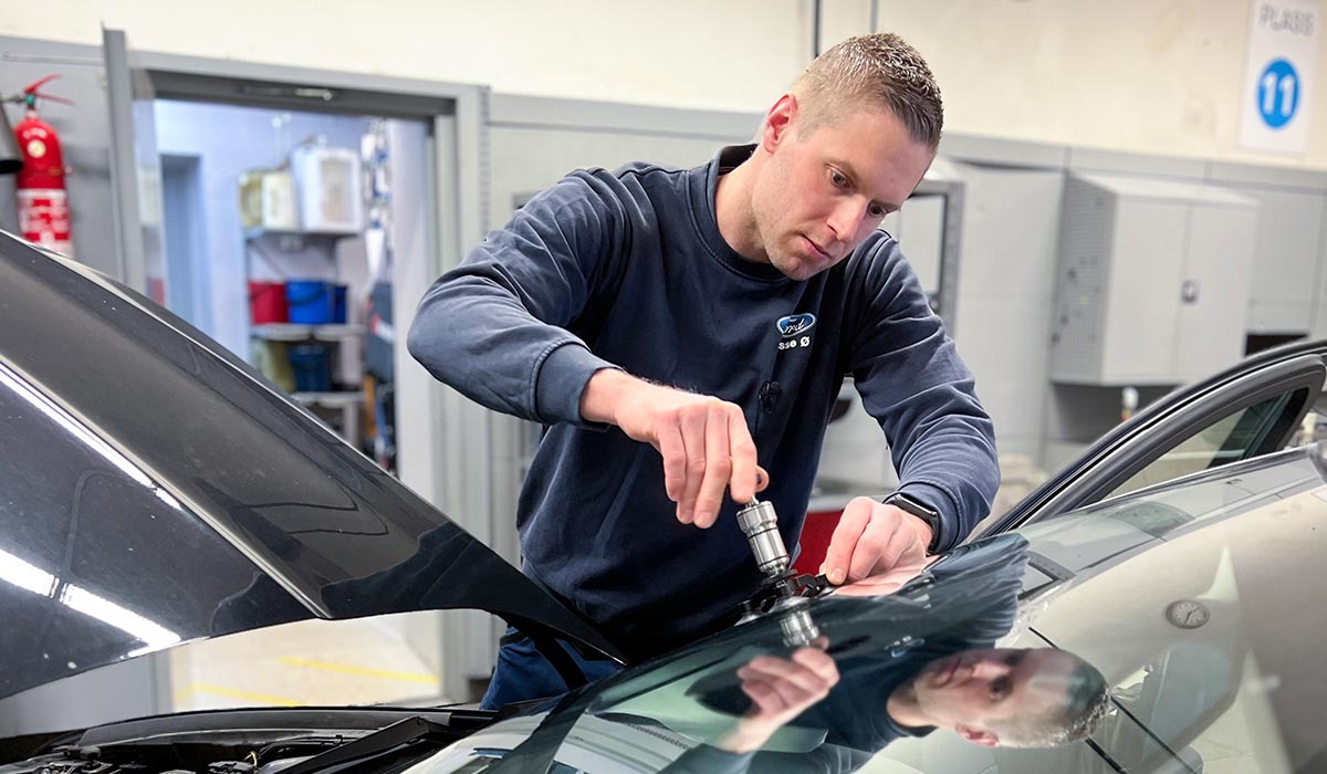 Servicemedarbeider hos Bilservice fikser rute