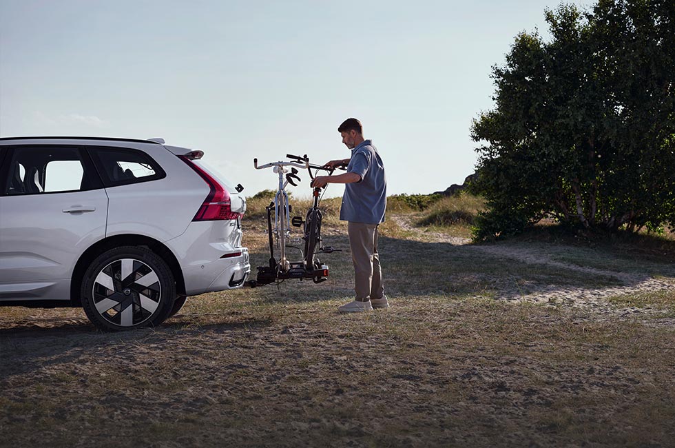 Mann som laster sykler på et sykkelstativ på en Volvo